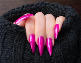 Pink stiletto shaped nails in warm cardigan