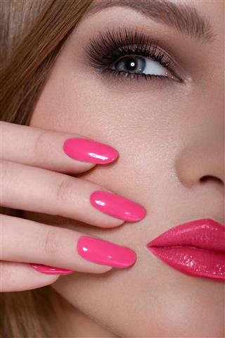 Manicure and Makeup. Beautiful Woman With Pink Nails