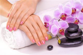 Beautiful manicure with pink orchid and towel