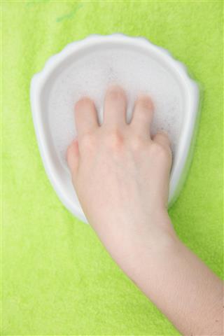 Hand in bath on green towel top view