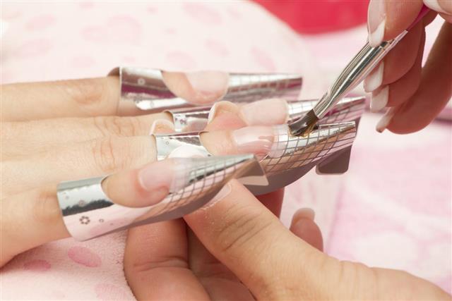 Beauty treatment, manicure applying wax on female fingernails