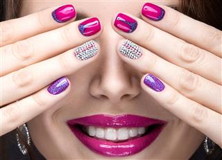 Girl with a bright evening make-up and pink manicure