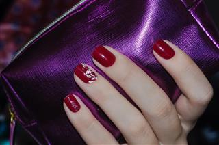 Woman hand with dark red nail design