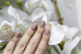 Beautiful female hand with beige nail design