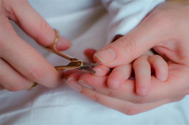 Mother cuts baby nails