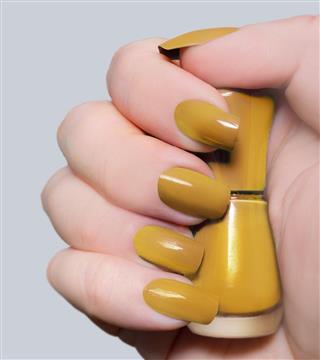 Spicy mustard colored nails and nail polish bottle