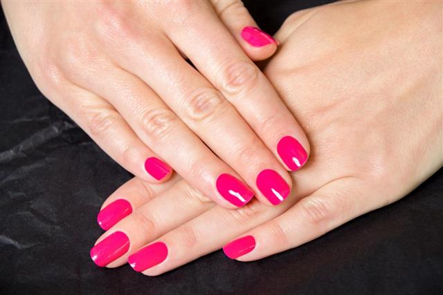 Female Hands Wearing Bright Pink Nail Polish