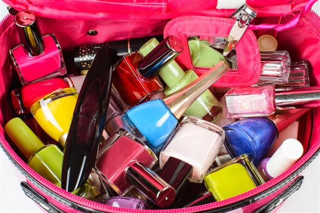 Set of nail polish, mascara, in a pink purse