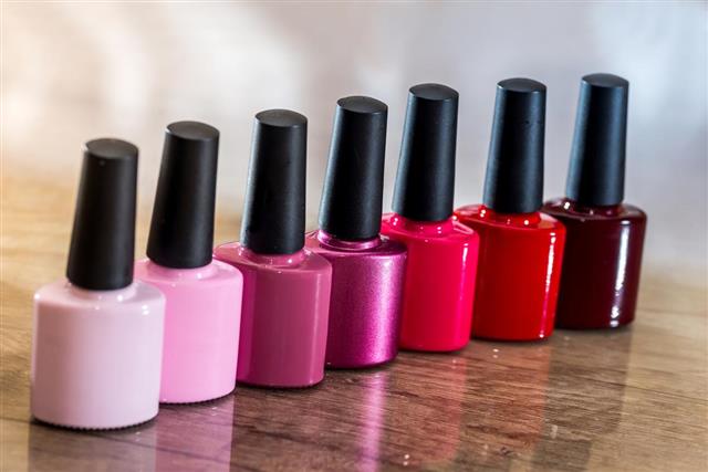 Group of bright nail polishes on wooden desk