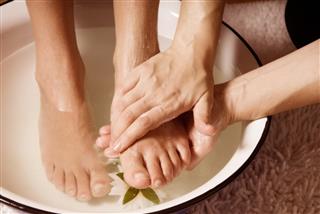 Closeup of woman feet on a bowl getting a pedicure