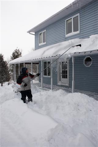 Man Shovelling Snow From Roof