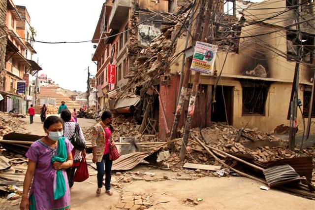 People Walk On Earthquake Damaged Street
