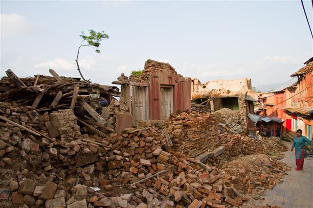 Woman Amongst Earthquake Rubble Of Home