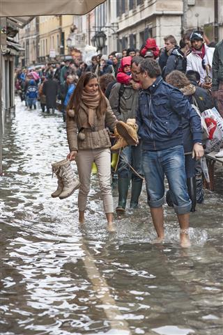 People Walking Through A Flooded Street