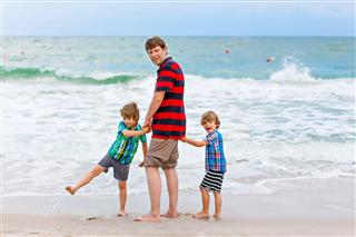 Two Boys And Father On Beach
