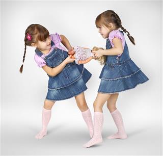 Twin Girls Fighting And Shared Doll