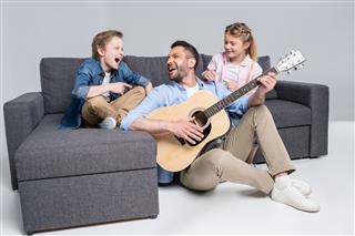 Happy Family Playing On Guitar