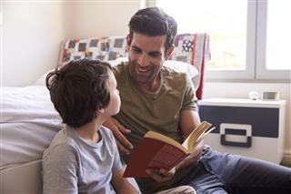Father And Son Reading Book Together