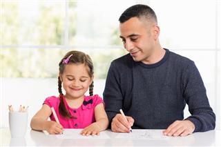 Girl And Father Drawing Pictures Together