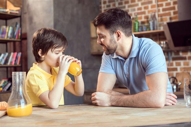 Father And Son Drinking Orange Juice