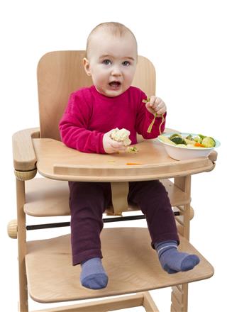 Young Child Eating In High Chair