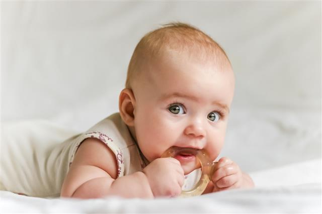 Baby With Teether In Mouth