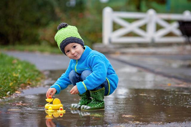 Boy Jumping In Muddy Puddles