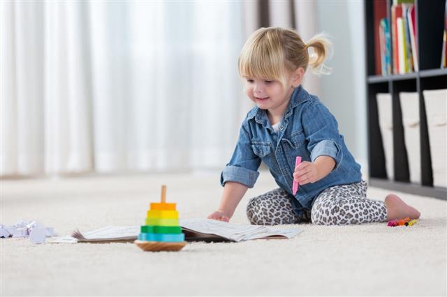 Sweet Toddler Plays On Floor In Her Home