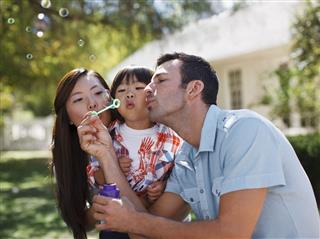 Family Blowing Bubbles Outdoors