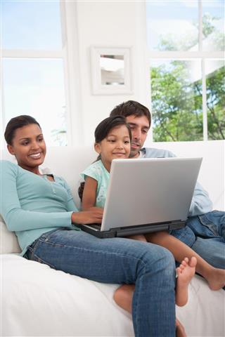 Couple with daughter at laptop