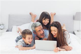 Cheerful Family Lying on Bed