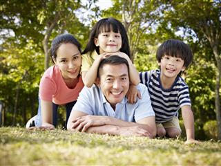 Happy asian family outdoors in park