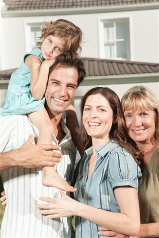 A family embracing in front of a large home