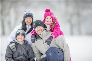 Family Sitting Together Out in Snow