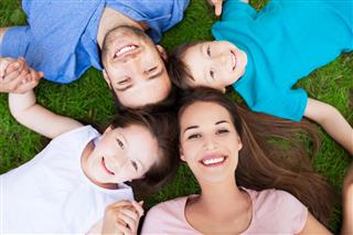 Family outdoors lying on grass