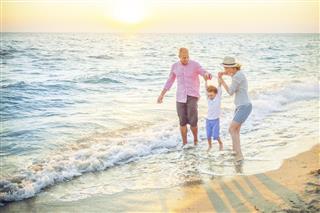 Happy family walking along a sandy beach