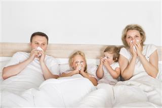 Sick Family Lying In Bed