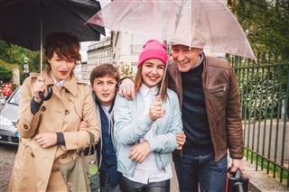 Happy french family out in the rain