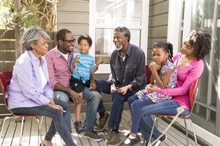 Multi generation African American family on decking outside house