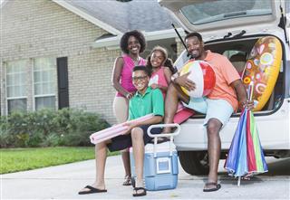 Family packing car for trip to the beach or pool