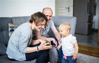 Parent showing pictures on a smartphone to their child
