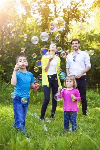 Happy family playing with Soap Bubbles