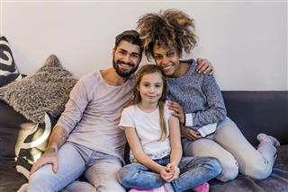 Mixed race couple and daughter looking at camera