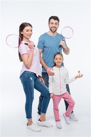 Smiling family with badminton rackets and shuttlecock on white