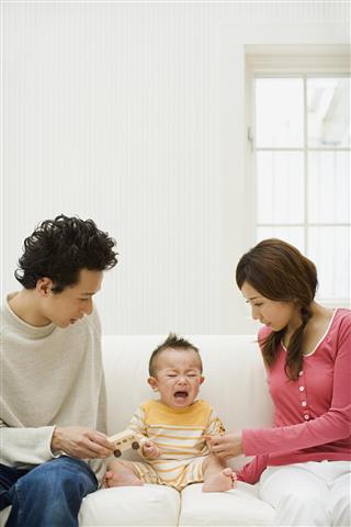 Crying baby with parents