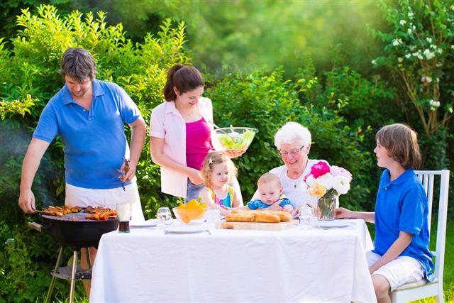 Big happy family enjoying barbecue grill in the garden