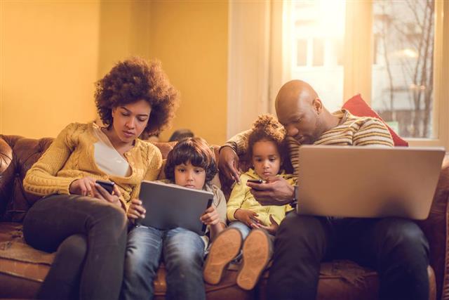 African American family using wireless technology at home