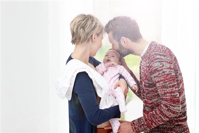 Young couple with their cute little baby girl