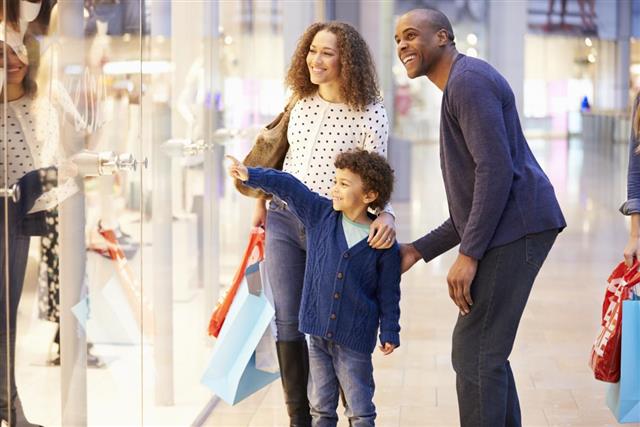 Child On Trip To Shopping Mall With Parent