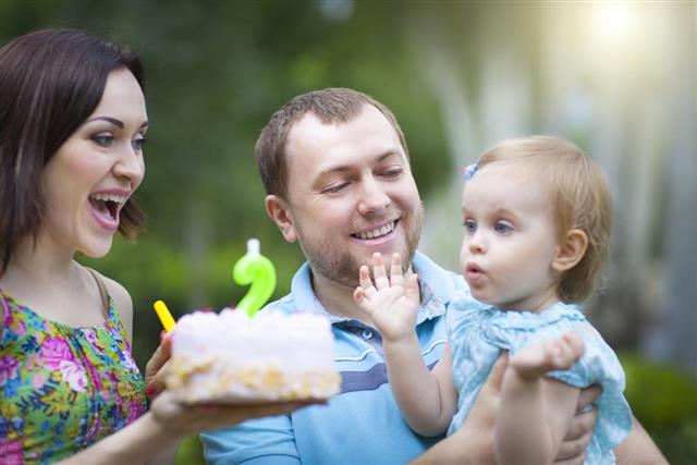 Happy family celebrating second birthday of baby daughter